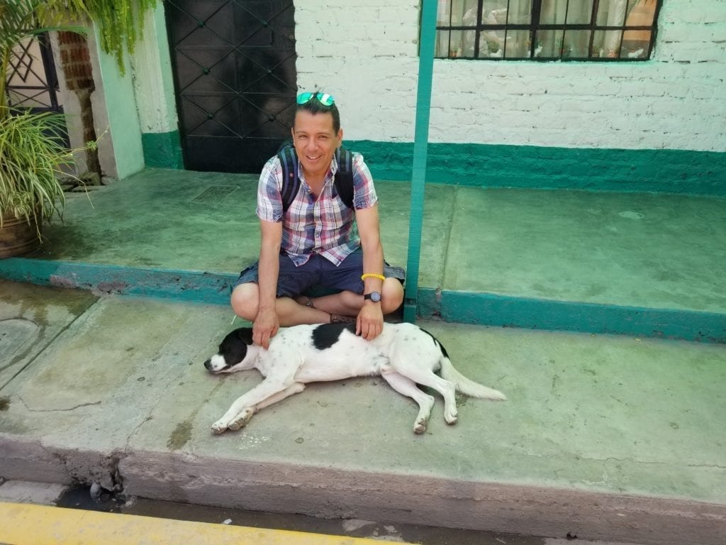 Ray petting a street dog who is happy to get some love food and belly rubs!